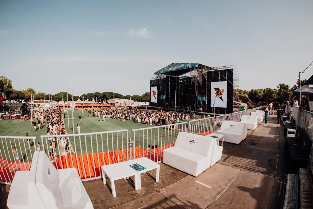 Zona chill-out con sofás sobre césped artificial en un evento