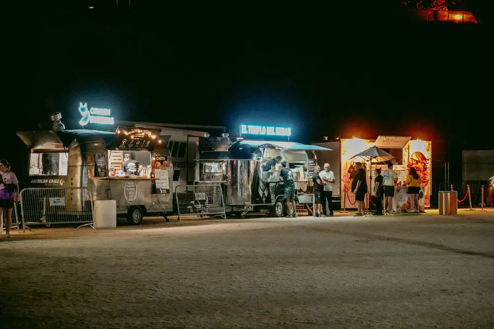 Zona de food trucks en plena noche durante un evento multitudinario